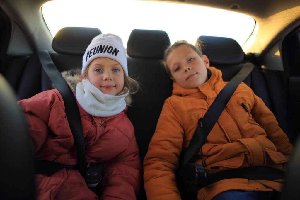 Children are seated in the back seat of the car. Road safety system